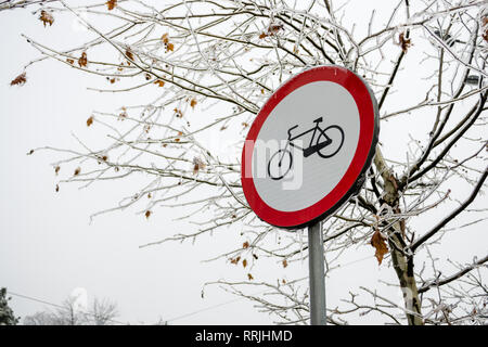 Pas de vélos admis signe sur l'hiver glacial, avec un arbre couvert de pluies glacées en arrière-plan, en hiver, saison, avec ciel couvert. Banque D'Images