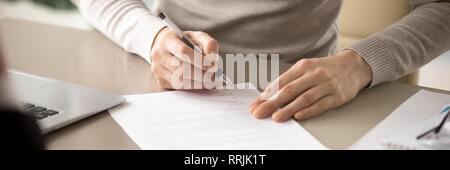 Close up female sitting at table tenir pen signature contrat Banque D'Images