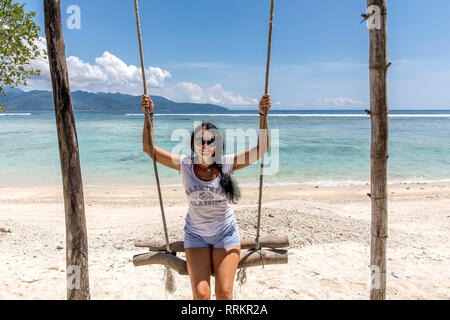 L'île de Gili Trawangan, Indonésie jeune femme se balançant sur swing. Banque D'Images