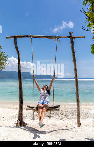 L'île de Gili Trawangan, Indonésie jeune femme se balançant sur swing. Banque D'Images