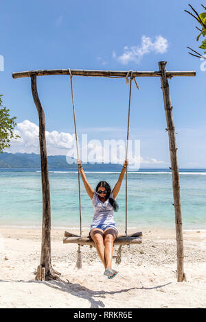 L'île de Gili Trawangan, Indonésie jeune femme se balançant sur swing. Banque D'Images