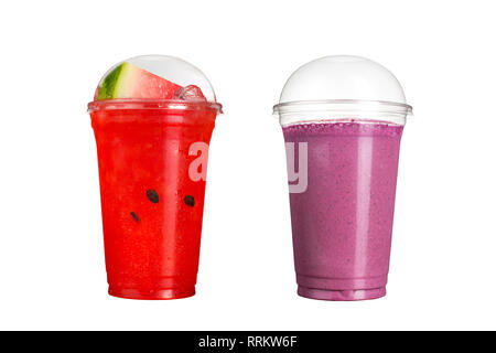 De délicieux smoothies aux fruits dans des gobelets en plastique, sur un fond blanc. Deux cocktails avec le goût de la pastèque et le goût de fruits sauvages. Isolé Banque D'Images