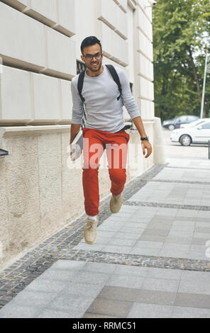 Full Length portrait of happy young man running Banque D'Images