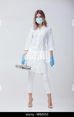 Femme médecin avec masque et des gants médicaux est titulaire d'un metal sac avec les instruments médicaux Banque D'Images