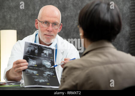 Une femme mature et médecin patient Xray in medical office Banque D'Images
