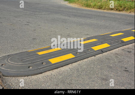 Traffic safety ralentisseur sur une route asphaltée. Des ralentisseurs (vitesse ou les disjoncteurs) sont le nom commun d'une famille de dispositifs de modération de la circulation. Banque D'Images