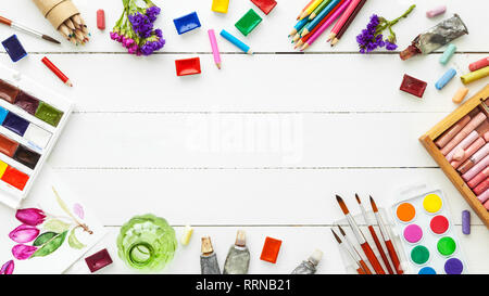 Les peintures à l'aquarelle, les pinceaux pour la peinture, crayons, crayon pastel blanc sur la table. Vue d'en haut. Mise à plat. Banque D'Images