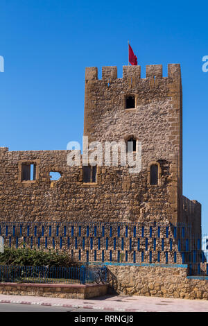 Les murs en pierre de l'ancienne forteresse portugaise (château) Dar el Bahar avec une tour et drapeau marocain sur le dessus. Situé sur la côte de l'océan Atlantique Banque D'Images