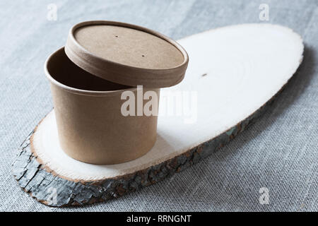Tasse de papier kraft jetable sur une planche de bois. Banque D'Images