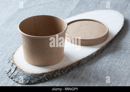 Tasse de papier kraft jetable sur une planche de bois. Banque D'Images
