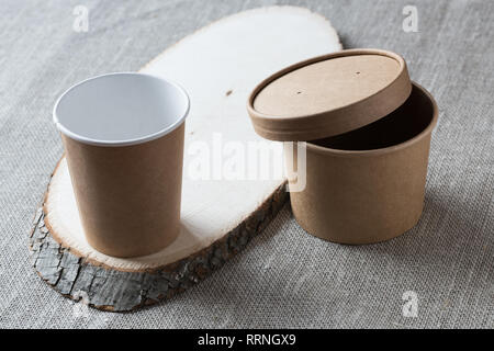Tasse de papier kraft jetable sur une planche de bois. Banque D'Images