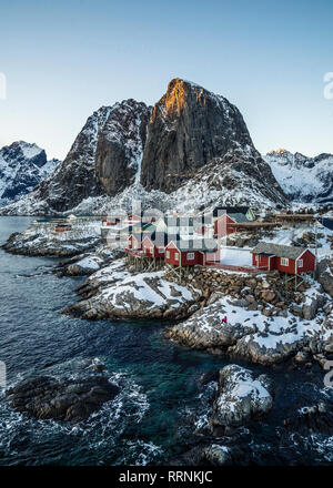 Couvert de neige tranquille village de pêcheurs au bord de l'eau et de falaises, de Hamnoy, îles Lofoten, Norvège Banque D'Images