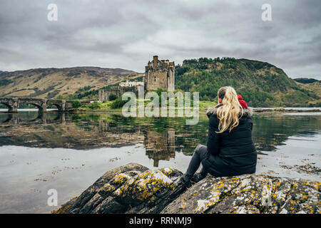 Woman enjoying view de remote, waterfront castle, Scotland Banque D'Images
