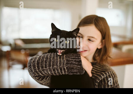 Portrait girl holding sifflement chat noir Banque D'Images