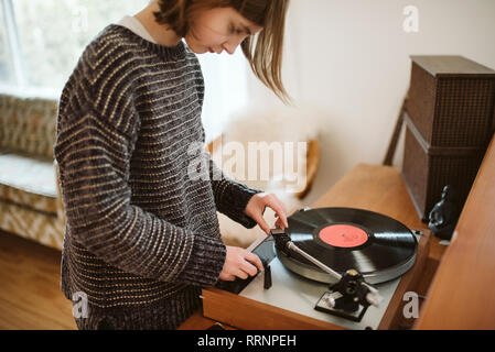 Girl playing vinyl record dans la salle de séjour Banque D'Images