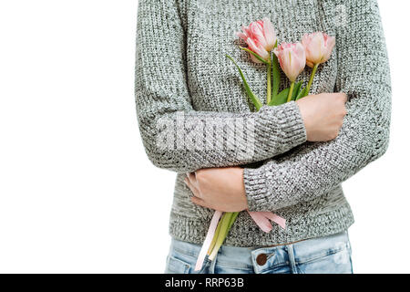 Jeune femme tenant des tulipes roses sur fond blanc. Banque D'Images