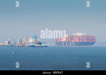 Le navire porte-conteneurs ultra large de 400 mètres, TIHAMA, passant devant la raffinerie pétrolière de Fawley, Royaume-Uni. En route pour la Havre, France. Banque D'Images