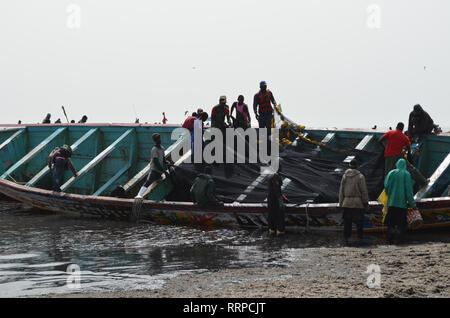 L'équipage d'une grande pirogue de rabattre les filets utilisés pour la pêche à la sardinelle et autres petites espèces pélagiques, Kayar, au Sénégal Banque D'Images