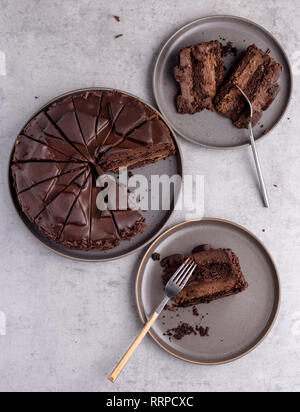 Vue de dessus la composition avec son ensemble de délicieux gâteaux au chocolat, les tranches sur des plaques de béton gris sur fond gris. Vue supérieure de la photo verticale. Concept de maison de vacances Banque D'Images