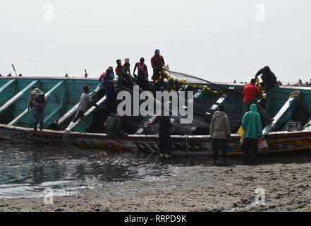 L'équipage d'une grande pirogue de rabattre les filets utilisés pour la pêche à la sardinelle et autres petites espèces pélagiques, Kayar, au Sénégal Banque D'Images