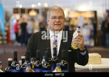 Rostock, Allemagne. Feb 26, 2019. Wolfgang Schareck, Recteur de l'université de Rostock, les boissons dont la présente étiquette anniversaire au 11e Salon des pays de boissons du commerce et de l'industrie. À l'occasion des célébrations du 600ème anniversaire de l'université de Rostock, vin rouge, de gin et de s'accoupler avec un anniversaire spécial boissons label sera vendu. Credit : Danny Gohlke/dpa/Alamy Live News Banque D'Images