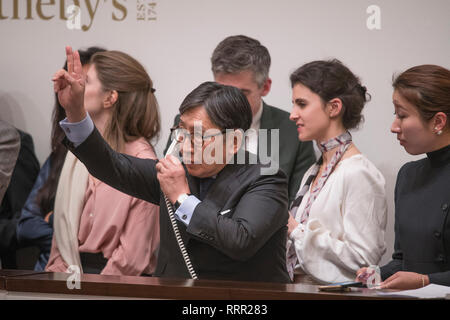 Sotheby's, New Bond Street, London, UK. 26 Février, 2019. Vente du soir d'œuvres majeures, impressionisme, surréalisme par de grands peintres modernistes et aura lieu à Londres. De droit : un membre de l'équipe de vente Sotheby's prend un téléphone offre de palais vénitien de Monet à £21 000 000 avant que le prix s'élève à 27 534 000 €. Credit : Malcolm Park/Alamy Live News. Banque D'Images