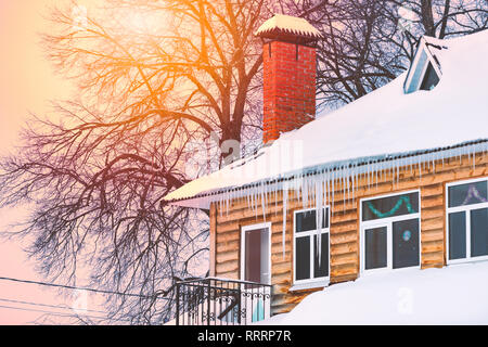 Maison en bois couverte de neige et de glaçons. L'hiver en Russie. Banque D'Images