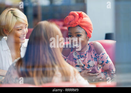 Les jeunes femmes friends talking in cafe Banque D'Images