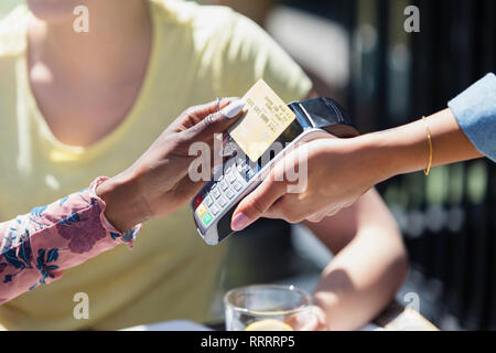 Serveuse femme de payer avec une carte à puce Banque D'Images