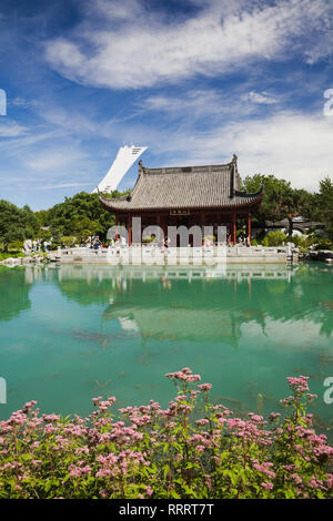 Pavillon Hall de l'amitié et Lac de rêve en été au Jardin Chinois avec Stade olympique tour en arrière-plan. Jardin botanique de Montréal, Québec,Canada Banque D'Images