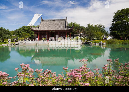 Pavillon Hall de l'amitié et Lac de rêve en été au Jardin Chinois avec Stade olympique tour en arrière-plan. Jardin botanique de Montréal, Québec,Canada Banque D'Images