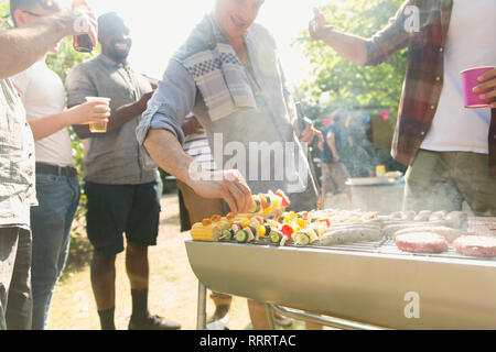 Amis barbecue dans jardin Banque D'Images