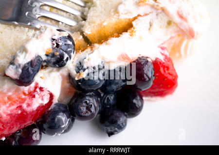 Biscuit moelleux délicieux gâteau crème au beurre assaisonné et couvert avec des bleuets frais et fraises - un dessert agréable et saine d'esprit Banque D'Images