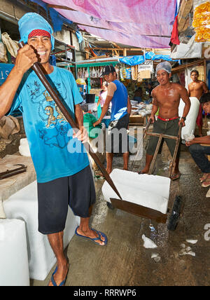 Puerto Princesa City, Palawan, Philippines - Le 25 février 2010 : Portrait de jeunes travailleurs masculins de l'énorme marché humide de blocs de glace pour les clients Banque D'Images