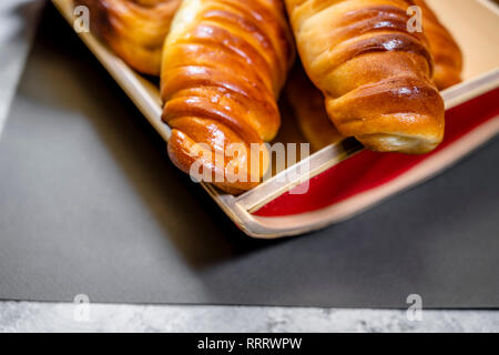 Délicieux délicieux petits pains cuits émaillés ruddy, tartes et pâtisseries à la cannelle et diverses garnitures, fabriqué à partir de farine biologique premium, disposés sur un woo Banque D'Images