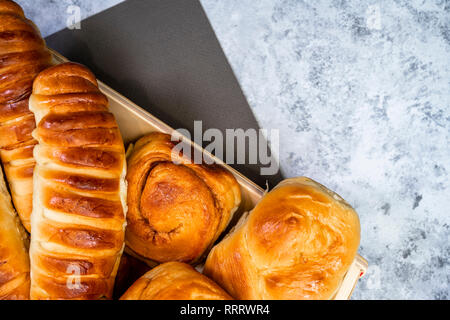 Délicieux délicieux petits pains cuits émaillés ruddy, tartes et pâtisseries à la cannelle et diverses garnitures, fabriqué à partir de farine biologique premium, disposés sur un woo Banque D'Images