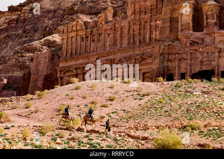 Une famille est en train de faire un tour de chameau est un Bédouin, tout en les conduisant dans le magnifique site archéologique de Pétra. Banque D'Images