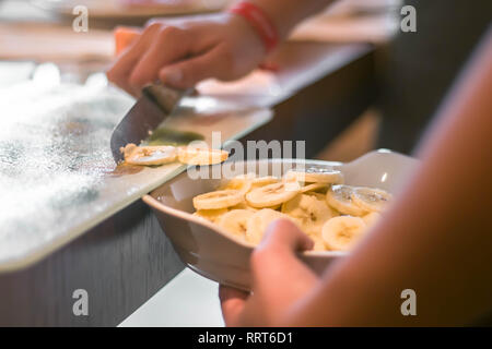 Les tranches de banane coupée au couteau dans un bol. Close up photo Banque D'Images