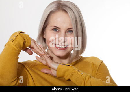 Belle Femme d'âge moyen Smiles émotionnellement posant en studio sur fond blanc Banque D'Images