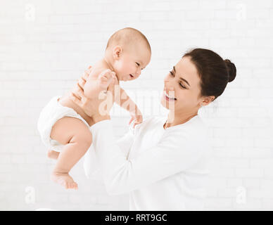 Mère de faire les exercices de renforcement pour son adorable bébé Banque D'Images