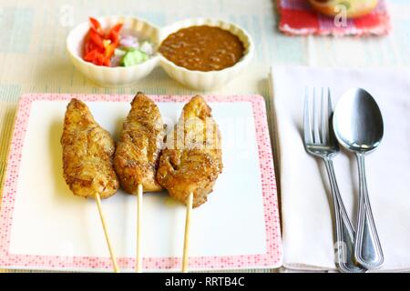 Satay de poulet servi avec sauce aux arachides Banque D'Images