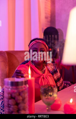 African American plump cartomancienne dans parures ethniques bien souriante Banque D'Images