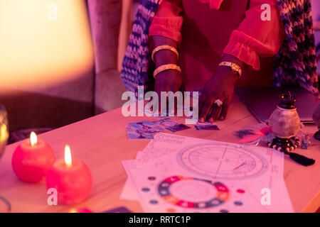 African American plump cartomancienne avec bracelets or cartes déplacement Banque D'Images