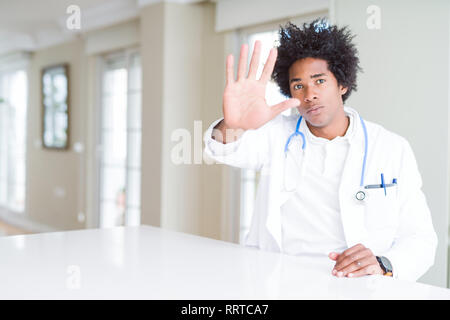 African American man médecin à la clinique faire arrêter de chanter avec paume de la main. Expression d'avertissement avec négatif et geste sérieux sur le visage. Banque D'Images