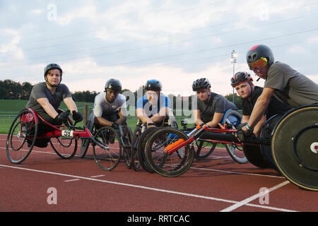 Portrait confiant, déterminé les athlètes paraplégiques en fauteuil roulant pour la formation sur piste de course sports Banque D'Images