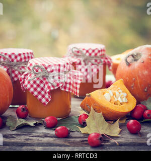 Confiture de citrouille ou de sauce et de citrouilles sur table en bois à l'extérieur. Encore l'automne de la vie. Focus sélectif. Banque D'Images