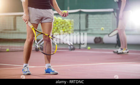 Tennis. Les jeunes hommes frapper la balle depuis le sol Banque D'Images