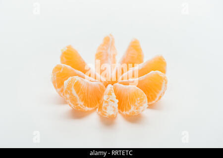 Tranches de mandarine orange mûre disposées en cercle sur fond blanc Banque D'Images