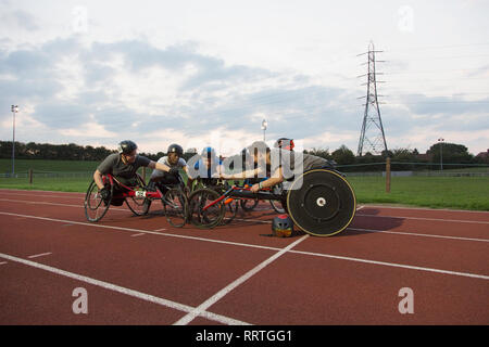 Les athlètes paraplégiques piaillent sur piste sports, course en fauteuil roulant pour la formation Banque D'Images