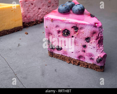 Blueberry cheesecake sur le béton avec des bleuets, à l'arrière-plan jaune et rose gâteaux, selective focus Banque D'Images